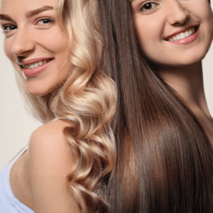 Two smiling women with long, contrasting blonde and brunette hair standing back-to-back representing Treatments. Link goes to Services page.